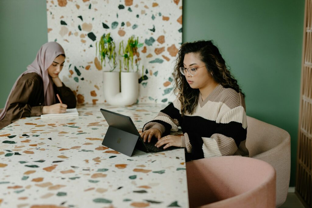 Two women setting at a table working